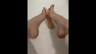 Fine whore in the bathroom masturbating with her feet and herself